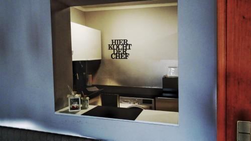 フィラッハにあるHappyStayApartmentsの鏡に流し台付きキッチンの映り