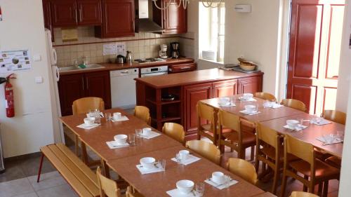 een keuken met houten tafels en stoelen in een kamer bij AuxR Etape La Maison du Randonneur in Auxerre