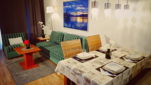 a living room with a table and a green couch at HappyStayApartments in Villach