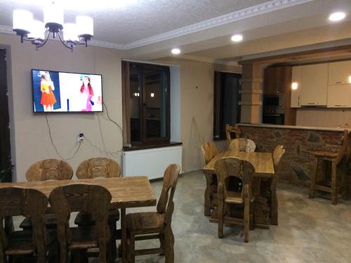 a room with tables and chairs and a tv on the wall at Hotel Elegant in Stepantsminda