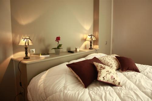 une chambre avec un lit avec deux lampes dessus dans l'établissement La Maison d'Adelaïde, à Saint-Flour