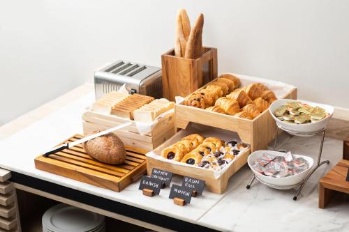a bunch of different types of bread and pastries on a counter at LIV Hotel Phuket Patong Beachfront in Patong Beach