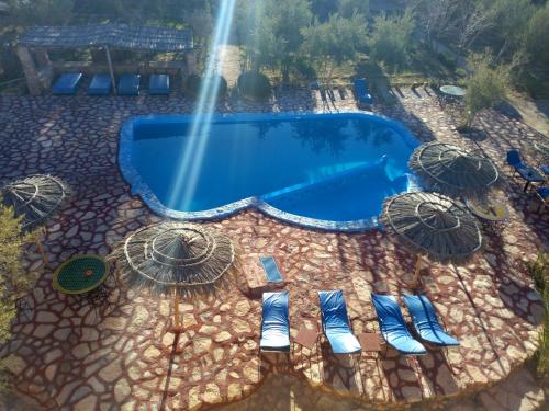 an overhead view of a swimming pool with chairs and umbrellas at Dar Mouna La Source in Aït Ben Haddou