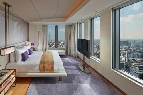 a bedroom with a large bed and large windows at Mandarin Oriental, Tokyo in Tokyo