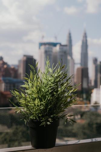 a plant sitting on a window sill with a city at Rex Ollie @ 231 TR Suite in Kuala Lumpur