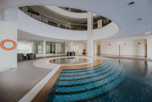 a swimming pool in a building with a large ceiling at Rex Ollie @ 231 TR Suite in Kuala Lumpur