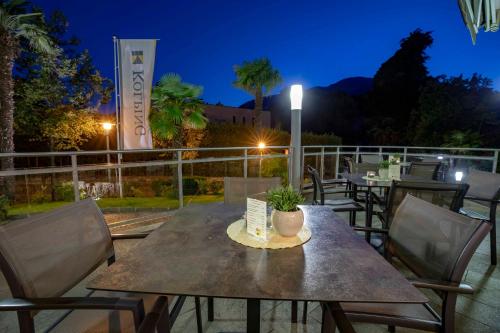 a table and chairs on a patio at night at Hotel Kolping in Merano