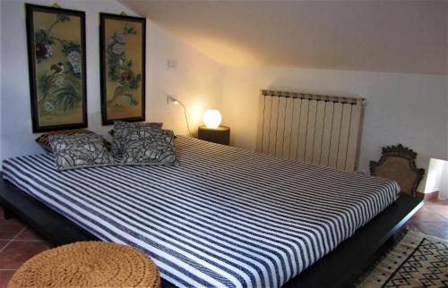 a bedroom with a large bed with a blue and white striped sheets at Residenza storica con vista panoramica in Perugia