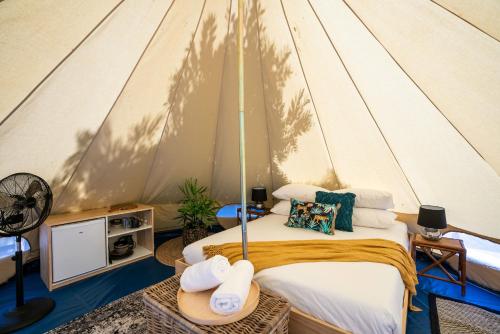 - une chambre avec un lit dans une tente dans l'établissement Castlemaine Gardens Luxury Glamping, à Castlemaine