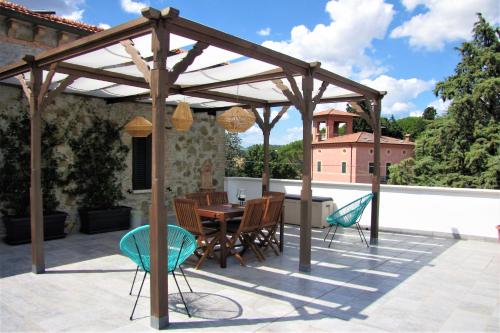 un pergolato in legno su un patio con tavolo e sedie di Residenza storica con vista panoramica a Perugia
