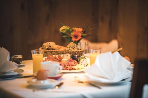 a table with a plate of food and a basket of food at Das Salvator Iris Porsche Landhotel in Friesach