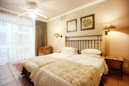 a bedroom with a large bed and a window at The Reef Apartments in East London