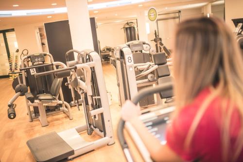 a woman in a gym on a treadmill at Das Salvator Iris Porsche Landhotel in Friesach