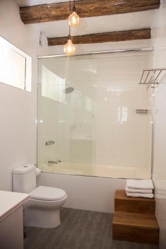 a bathroom with a toilet and a glass shower at La Casona Monsante in Chachapoyas