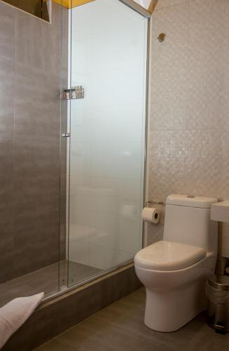 a bathroom with a toilet and a glass shower at La Casona Monsante in Chachapoyas