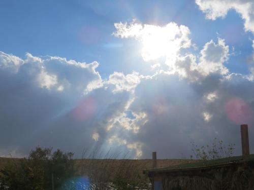 a cloudy sky with the sun in the sky at Succah in the Desert in Mitzpe Ramon