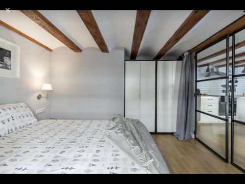 um quarto com uma cama e uma grande janela em WeRentVLC - Encantador Loft Casco Antiguo em Valência