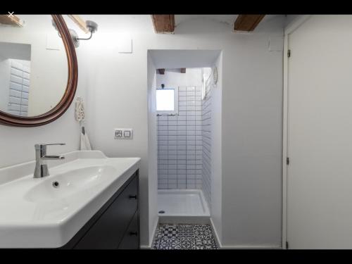 uma casa de banho branca com um lavatório e um chuveiro em WeRentVLC - Encantador Loft Casco Antiguo em Valência
