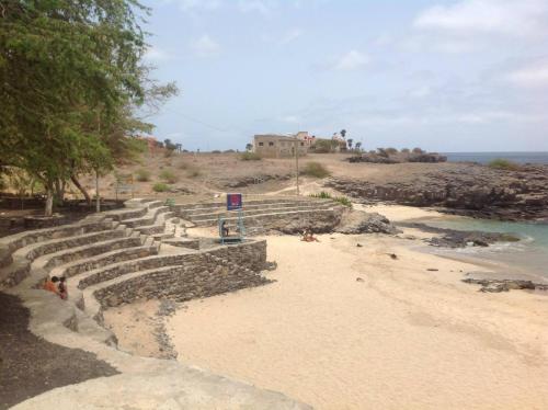 a sandy beach with a house on top of a hill at Casa Cabral : Big Apartment next to the beach in Tarrafal