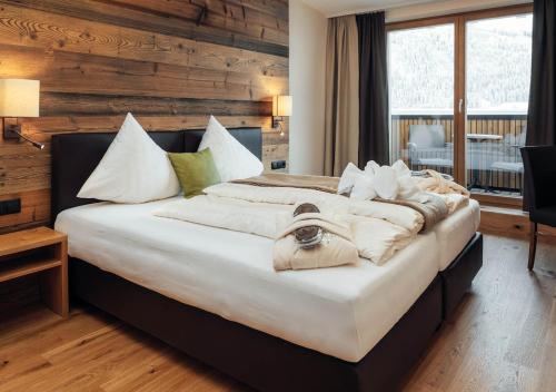 a bedroom with a large bed with white pillows at Hotel Garni Alpenjuwel Residenz in Serfaus