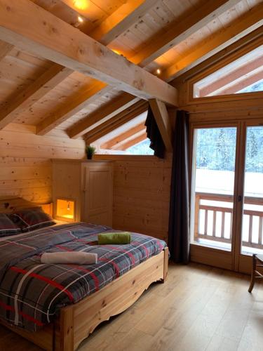 sypialnia z łóżkiem w drewnianym domku w obiekcie LE DARMA w mieście Sixt