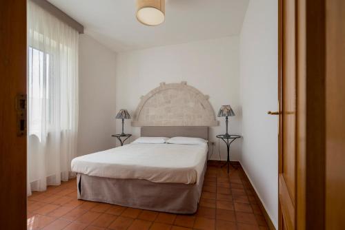 a bedroom with a white bed and two lamps at Villaggio Passo Dell'Arciprete in Vieste
