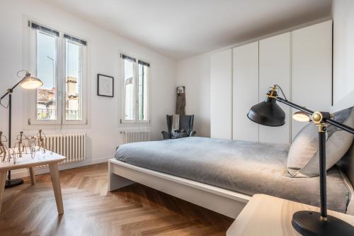 ein Schlafzimmer mit weißen Wänden und einem großen Bett in der Unterkunft La Bricola Terrace Apartment in Venedig