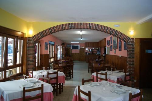 un comedor con mesas, sillas y un arco en Hotel Garganta del Cares en Poncebos