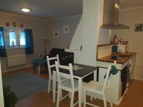 a kitchen and living room with a table and chairs at Hyttingsfabodstugor in Borlänge