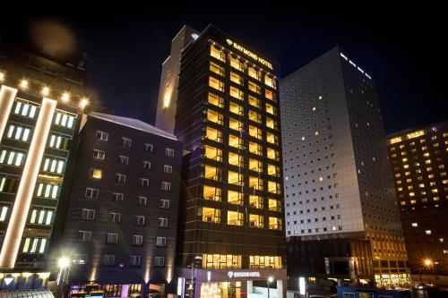 two tall buildings in a city at night at Baymond Hotel in Busan