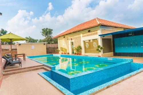 a swimming pool in front of a house at Kushal Palli Resorts- A unit of PearlTree Hotels & Resorts in Purulia