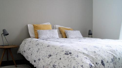 - une chambre avec un grand lit et une couette blanche dans l'établissement Little Suite - Albert, à Lille