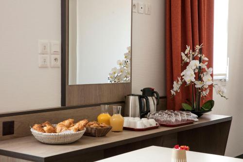 a counter with breakfast foods and orange juice on it at Hotel Clermont Estaing in Clermont-Ferrand
