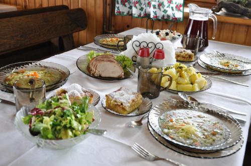 a table topped with plates of food and a salad at Antonówka in Trybsz