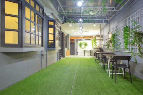 a room with tables and chairs and green carpet at G Beach Front Villa in Batu Ferringhi