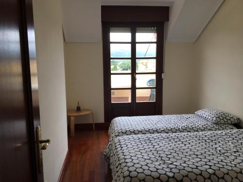 1 dormitorio con cama y ventana en Ático Nuevo con vistas en Cabezón de la Sal