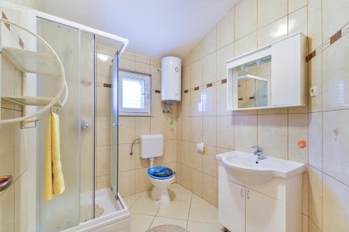ein Bad mit einem WC, einem Waschbecken und einer Dusche in der Unterkunft Apartmani Vugec in Vir