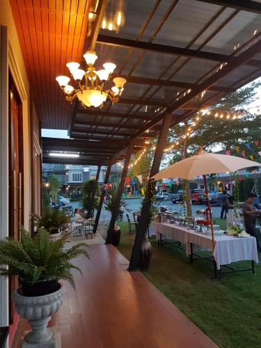 un ristorante con tavoli e un lampadario a braccio su un patio di Hotela Boutique Resort a Suphanburi