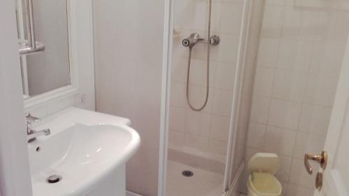 une salle de bain blanche avec une douche et un lavabo dans l'établissement 22 Place Saint-Roch, à Menton