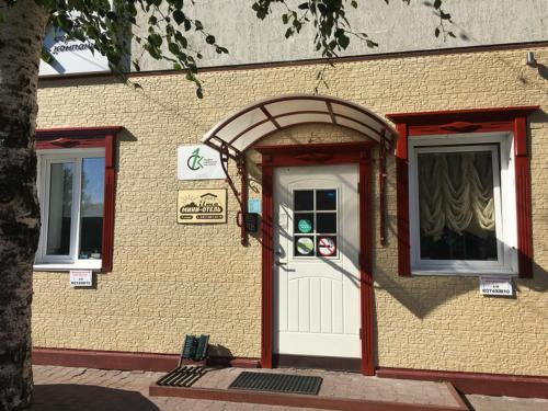 a building with a white door and an archway at Mini-Hotel Ilma in Petrozavodsk