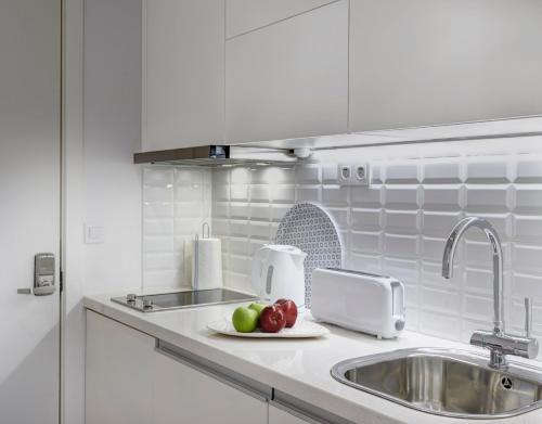 a kitchen counter with a sink and fruit on a plate at Porto Downtown Lovers Suites: Bombarda 451 in Porto