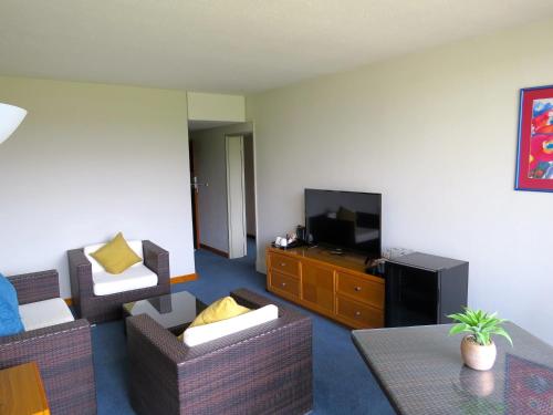 a living room with two chairs and a television at African Sky Harrismith Inn in Harrismith