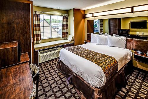 a hotel room with a large bed and a window at Microtel Inn and Suites North Canton in North Canton