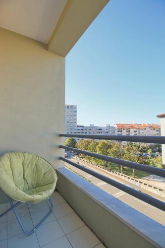 a green chair sitting on a balcony with a view at SResende Place Aveiro in Aveiro