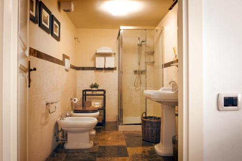 a bathroom with a toilet and two sinks and a shower at Antico Furlo in Acqualagna