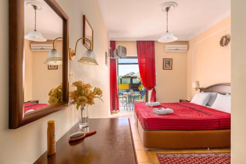 a bedroom with a red bed and a mirror at Corfu Secret in Ipsos