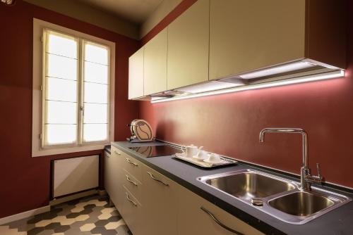 uma cozinha com um lavatório de aço inoxidável e uma janela em Liassidi Arco em Veneza