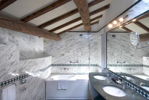 a bathroom with two sinks and a bath tub at Sina Brufani in Perugia