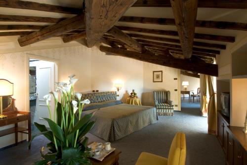 1 dormitorio con 1 cama en una habitación con techos de madera en Sina Brufani en Perugia
