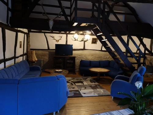 a living room with blue couches and a tv at Ferienhof Schmickerath in Simmerath